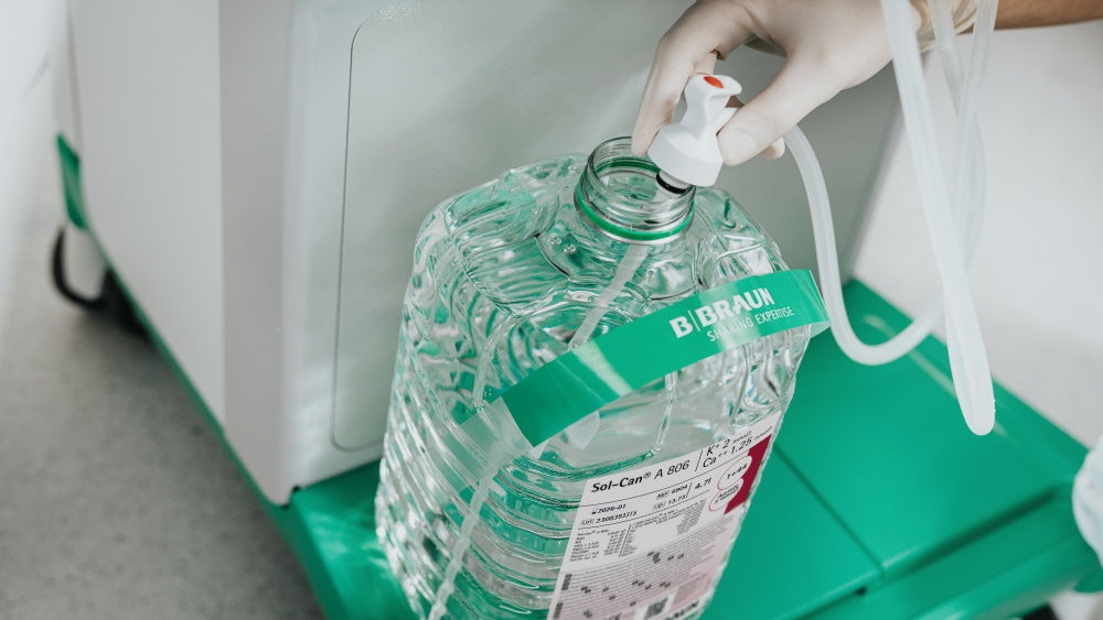 Hand of a medical worker holding a small tube in the sol-can canister to get the liquid from inside