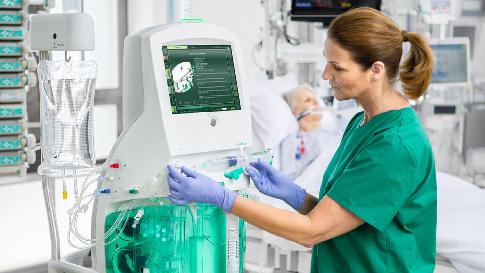 Intensive care nurse inserts a syringe into the OMNI acute dialysis machine