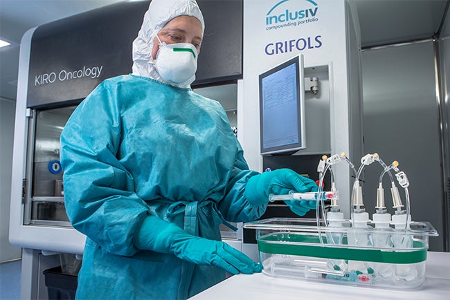 Pharmacist preparing drugs with automated compounding robot