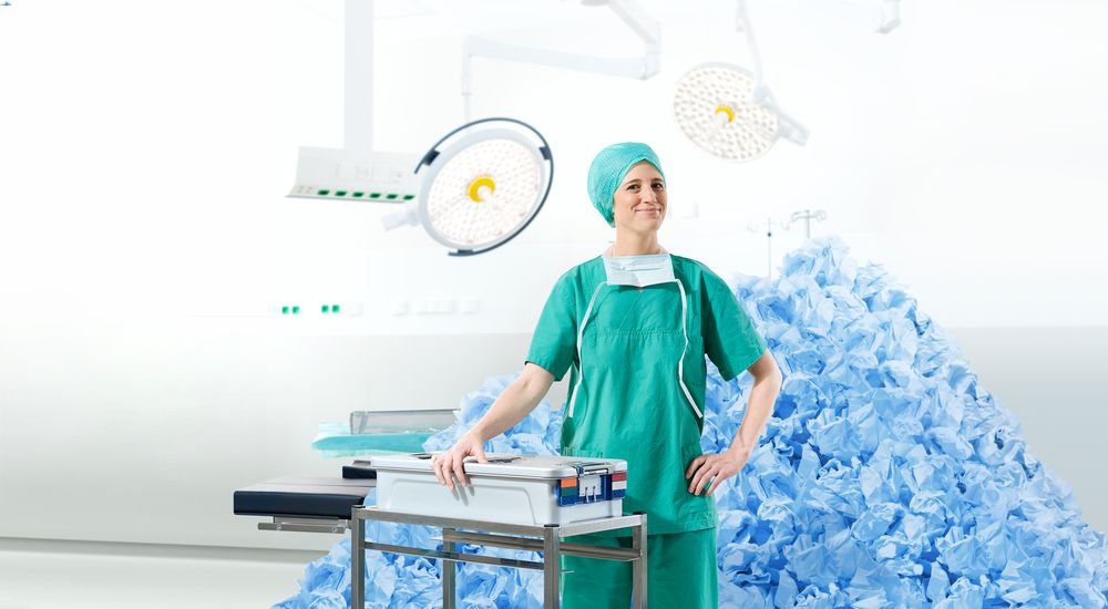 A healthcare professional is shown standing proudly with a sustainable-produced medical container.