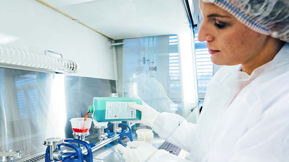 A medical laboratory employee is pouring liquid for a quality check.